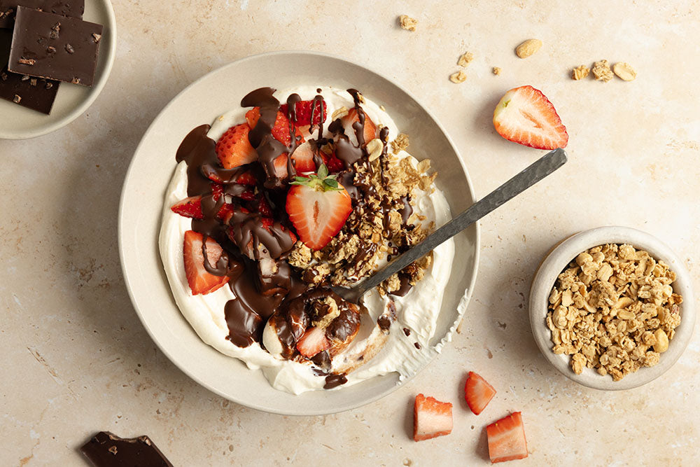 white-bowl-with-protein-yogurt-topped-with-granola-chocolate-and-strawberries